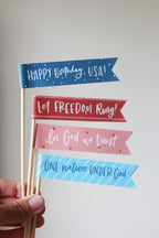 Small fourth of july flags that read happy birthday, USA, Let Freedom Ring, In God we trust, One nation under God