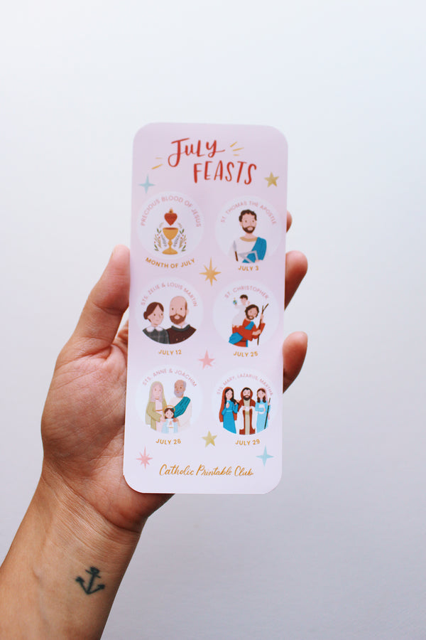 Hand holding a sticker sheet with illustrations and text on a light white background