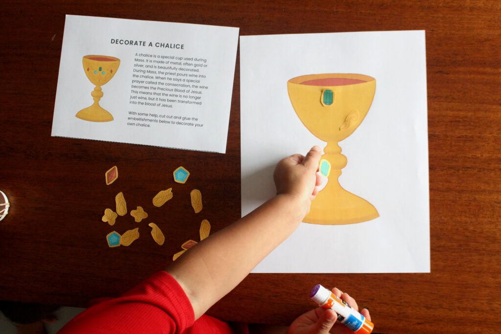 Child decorating chalice with gluing activity from the Precious Blood of Jesus activity bundle